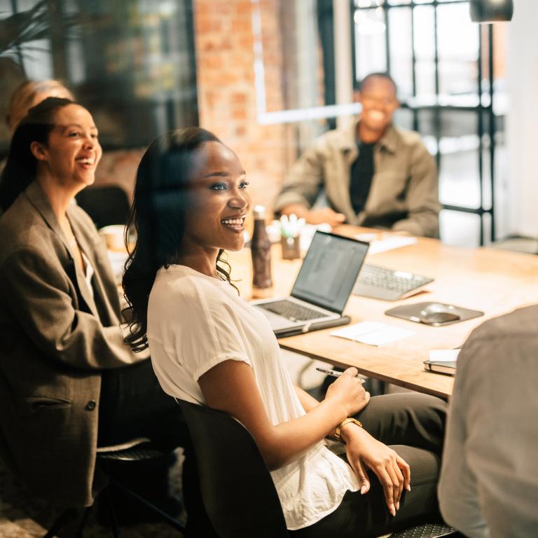 People gather in a meeting room to discuss work in an office