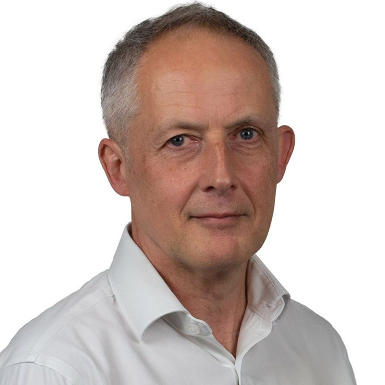 Photo of David Wreford a professional with a confident smile, wearing a suit against a neutral background.